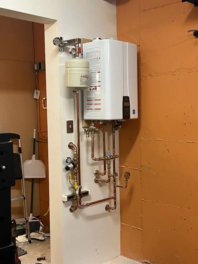 Plumbing technician inspecting water heater connections in Floyds Knobs